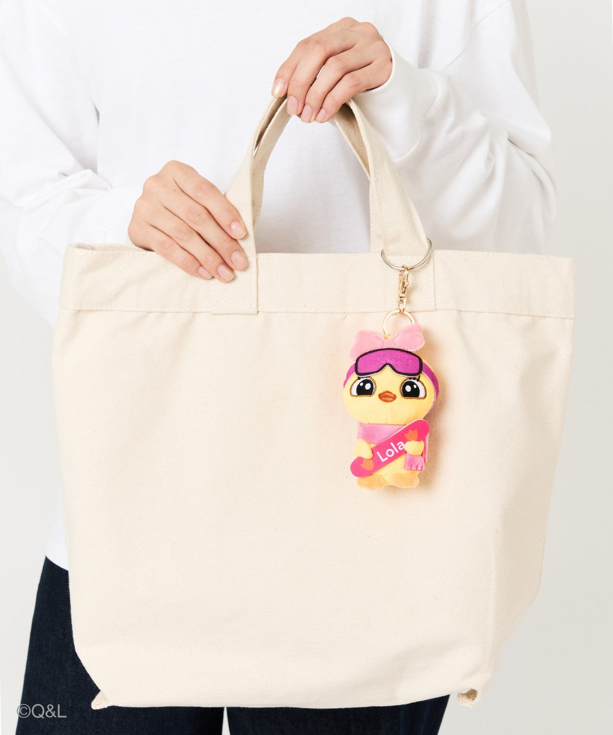 Snowboarding Mascot Lola on a tote bag, held